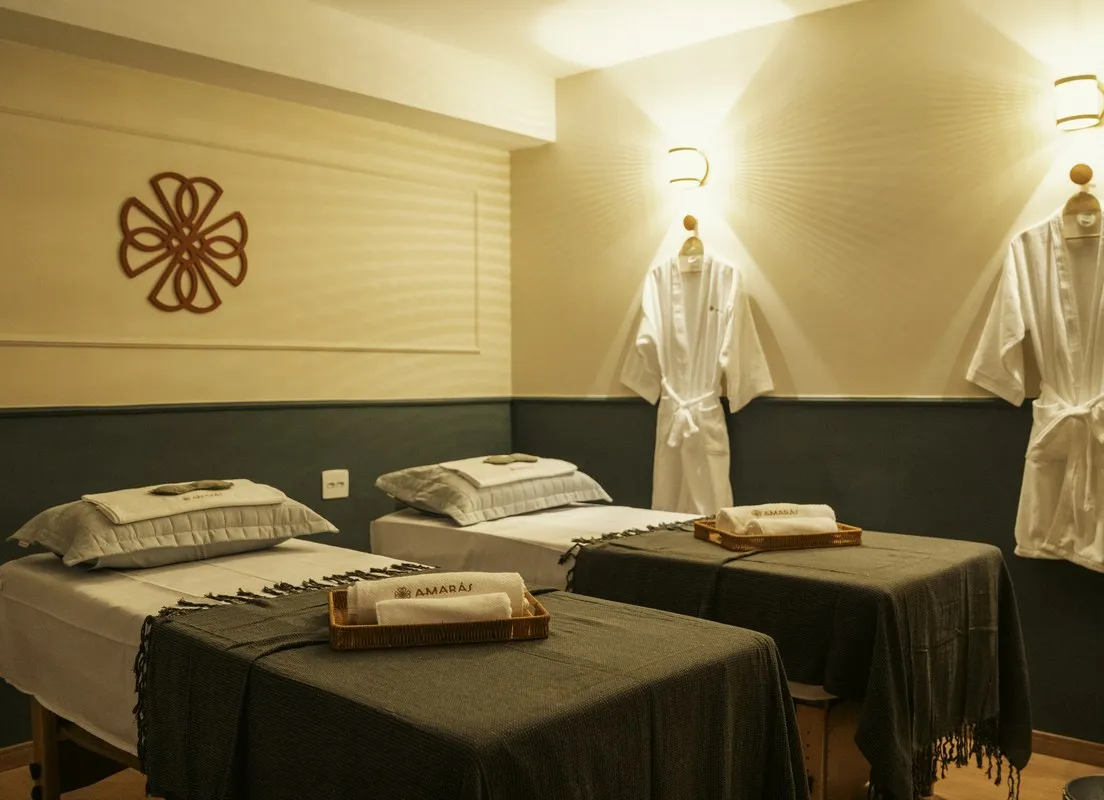 Sala dupla com duas macas, a mandala Amarás na parede e roupões pendurados