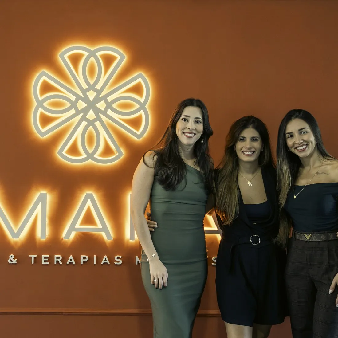 Equipe Amarás diante do letreiro iluminado na inauguração da unidade