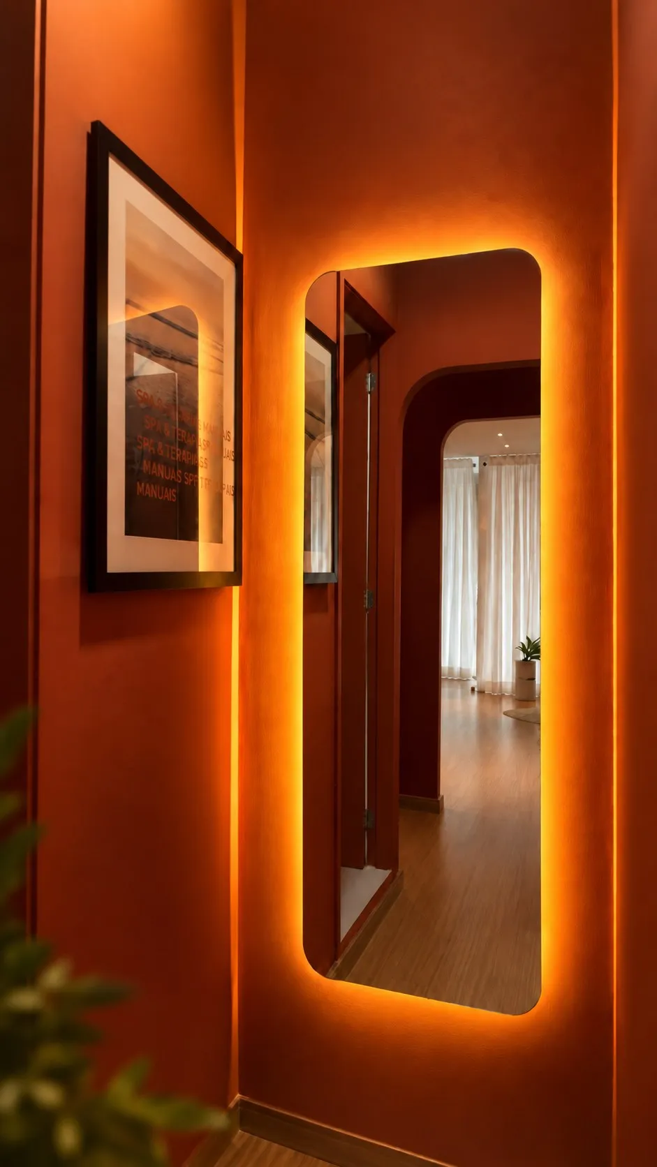Espelho com luz âmbar no corredor terracota, refletindo a sala ao fundo