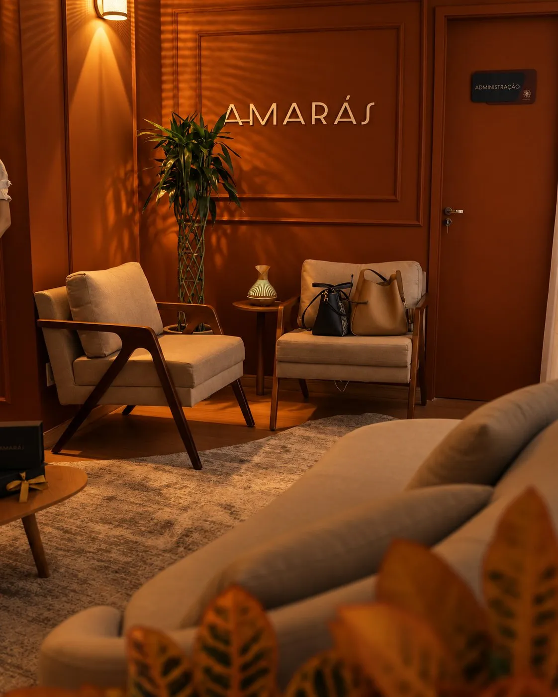 Lounge terracota com poltronas e o letreiro Amarás