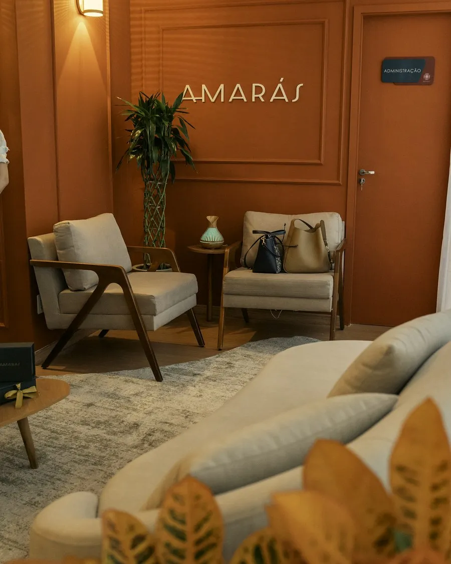 Lounge terracota com poltronas e o letreiro Amarás