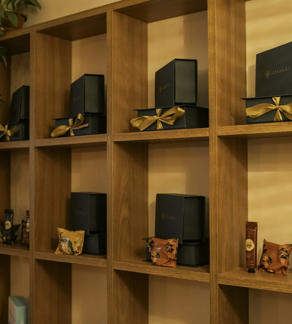 Estante com caixas de presente Amarás e laços dourados